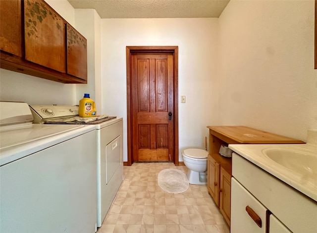 clothes washing area featuring washing machine and clothes dryer and a textured ceiling