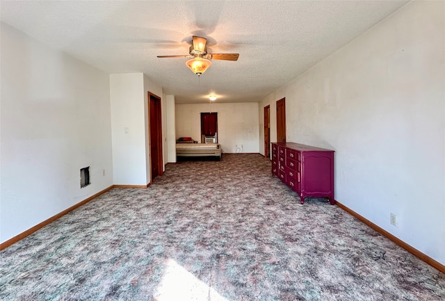 carpeted empty room with ceiling fan and a textured ceiling