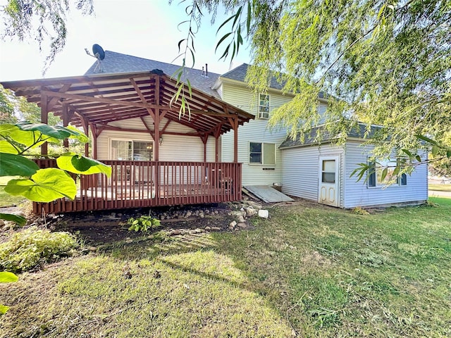 back of property featuring a pergola, a wooden deck, and a yard