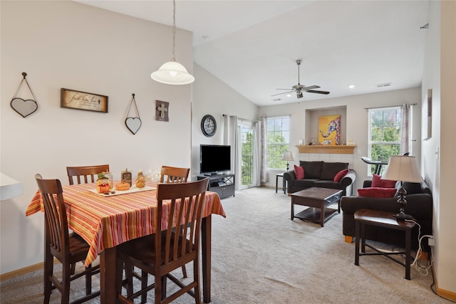 carpeted dining room with ceiling fan, high vaulted ceiling, and a healthy amount of sunlight