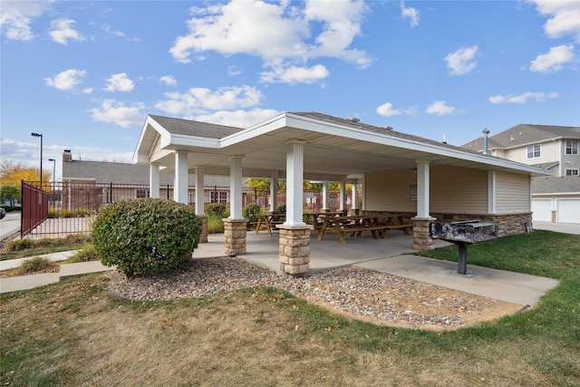 view of home's community with a garage, a lawn, and a patio area