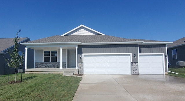 view of front facade featuring covered porch, a garage, and a front yard