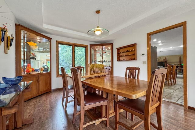 dining room with wood-type flooring and a textured ceiling