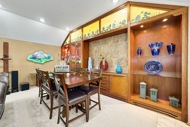 carpeted dining room with vaulted ceiling