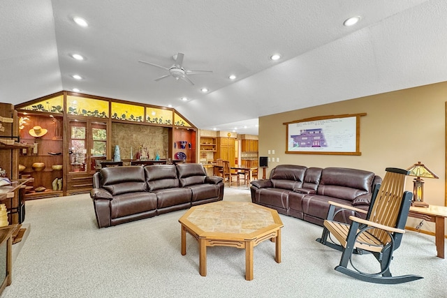 living room featuring ceiling fan, a textured ceiling, lofted ceiling, and carpet