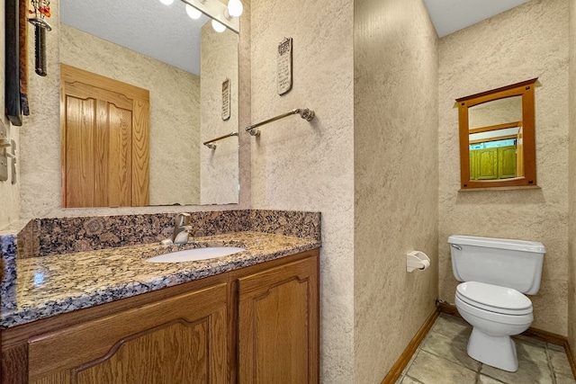 bathroom featuring a textured ceiling, tile patterned floors, vanity, and toilet