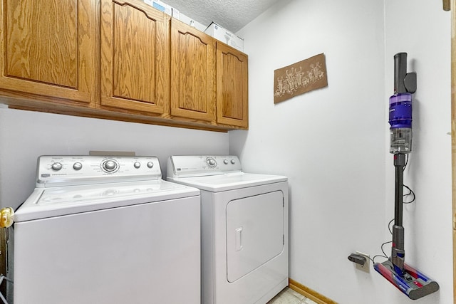 washroom with cabinets, a textured ceiling, and independent washer and dryer