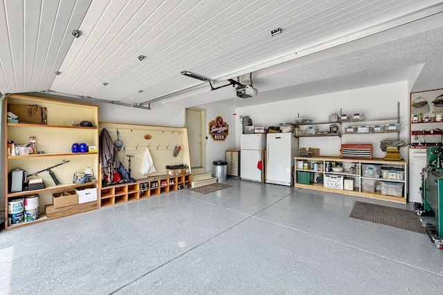 garage featuring a garage door opener and white refrigerator