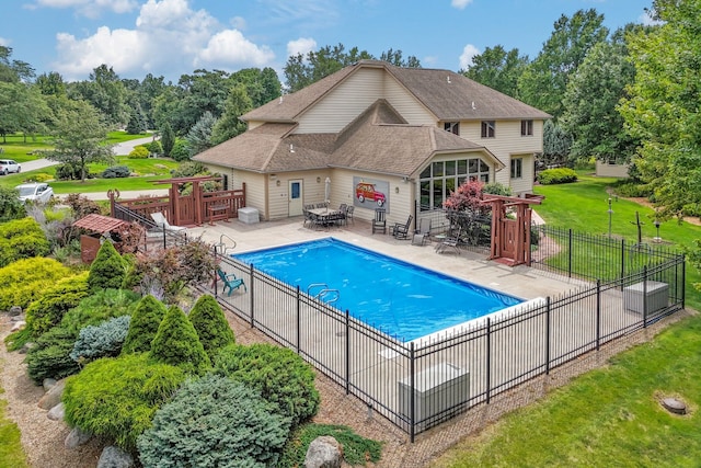 view of pool with a lawn and a patio area