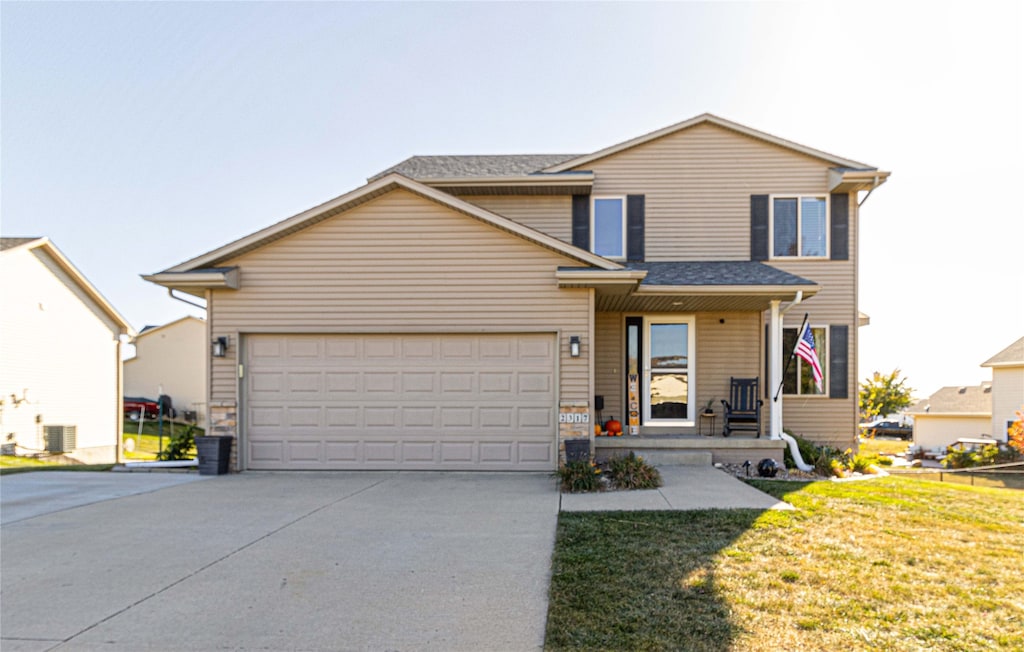 front of property with a front lawn, central AC unit, and a garage