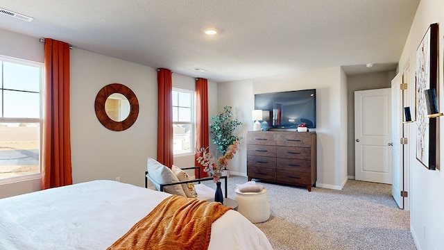 bedroom with a textured ceiling and light colored carpet