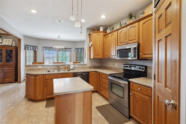 kitchen with an inviting chandelier, sink, hanging light fixtures, appliances with stainless steel finishes, and a center island