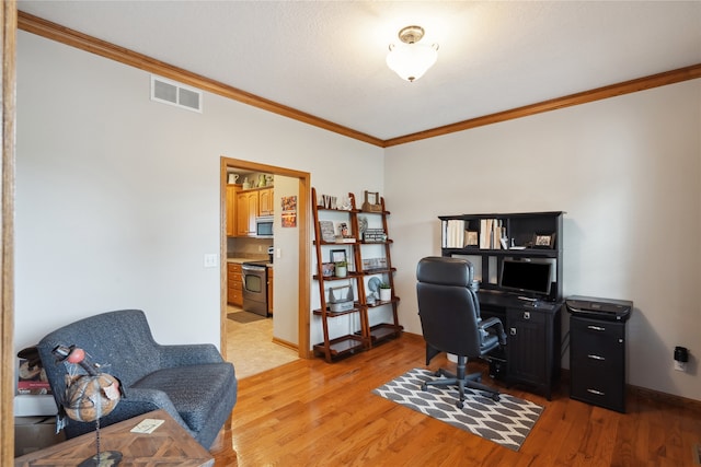 home office featuring light hardwood / wood-style floors and crown molding