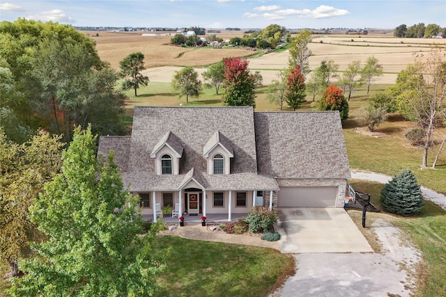 view of front of property with a front yard, a rural view, and a garage