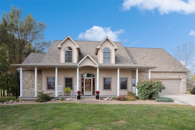 view of front of house featuring a front lawn, covered porch, and a garage