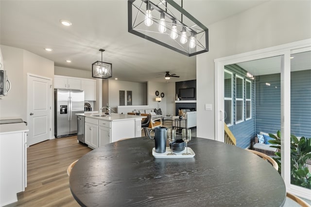 dining space with ceiling fan, sink, and hardwood / wood-style flooring