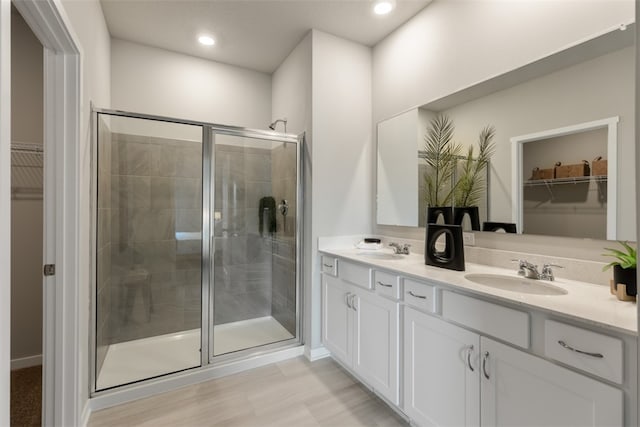 bathroom featuring wood-type flooring, vanity, and walk in shower