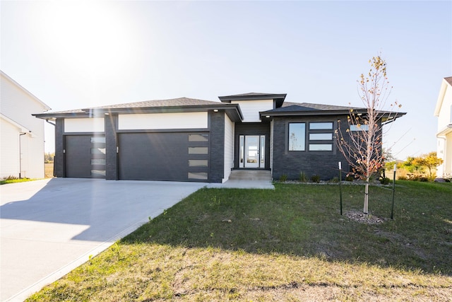 prairie-style home featuring a front lawn and a garage