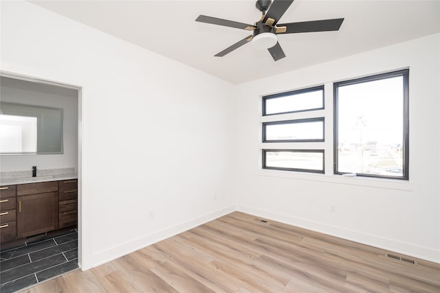 spare room featuring ceiling fan and light hardwood / wood-style floors