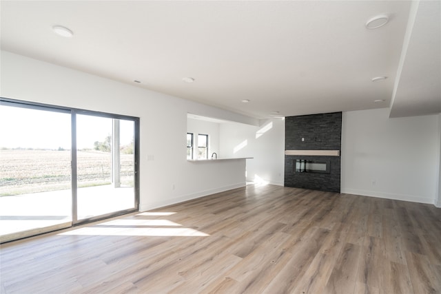 unfurnished living room with a fireplace and light hardwood / wood-style floors