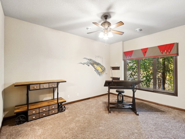 carpeted office space featuring ceiling fan