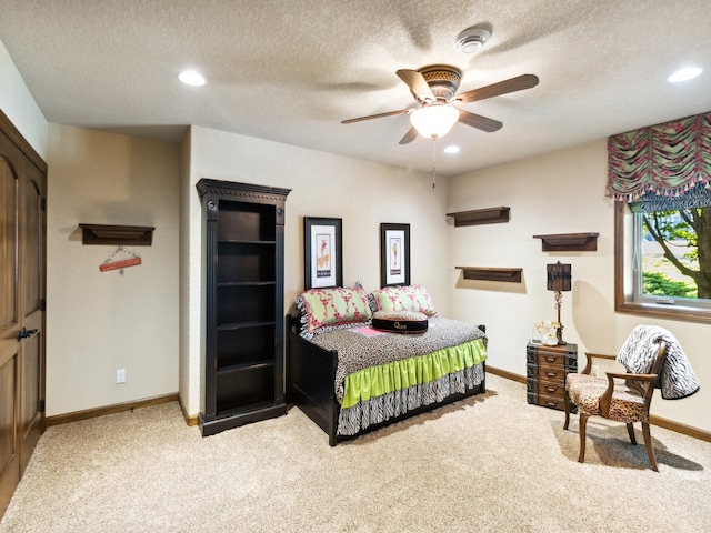 carpeted bedroom featuring ceiling fan and a textured ceiling