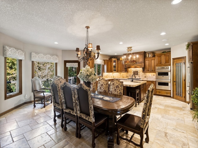 dining area with an inviting chandelier and a textured ceiling