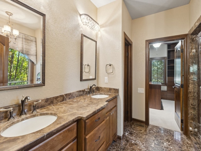 bathroom with an inviting chandelier, vanity, and plenty of natural light