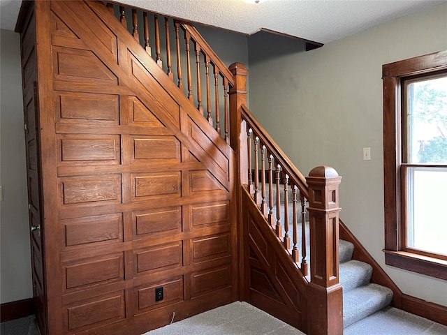 stairway with a textured ceiling