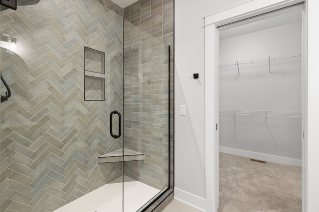 bathroom with a shower with door