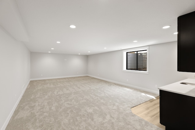 basement featuring light colored carpet