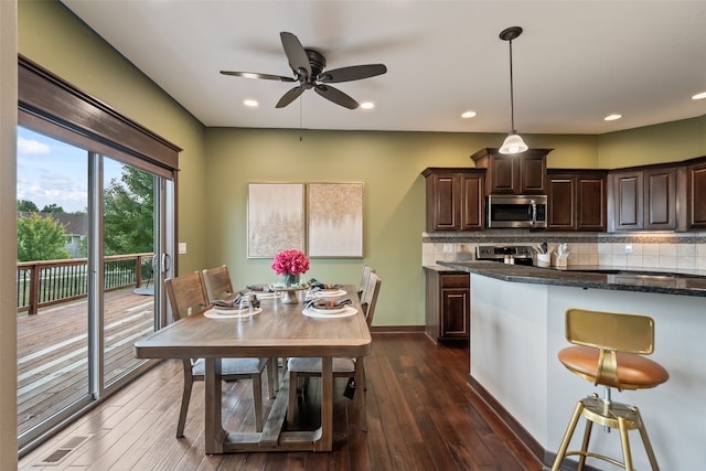 kitchen featuring appliances with stainless steel finishes, decorative light fixtures, dark hardwood / wood-style floors, and tasteful backsplash