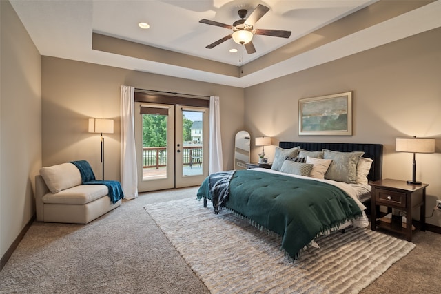 carpeted bedroom with access to exterior, ceiling fan, a tray ceiling, and french doors