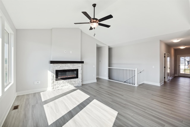 unfurnished living room with lofted ceiling, hardwood / wood-style flooring, a fireplace, and ceiling fan