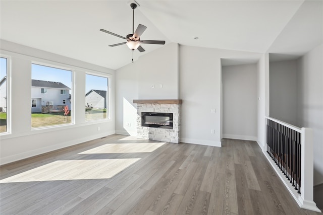 unfurnished living room with a fireplace, high vaulted ceiling, light wood-type flooring, and ceiling fan