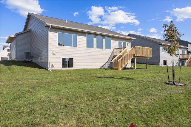 back of property with a wooden deck and a lawn