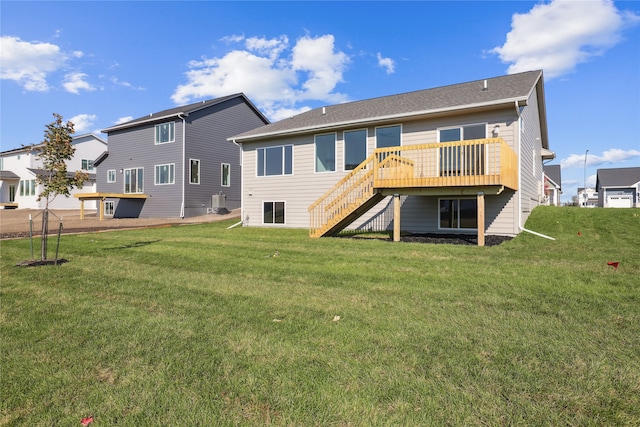 back of property with a deck and a lawn