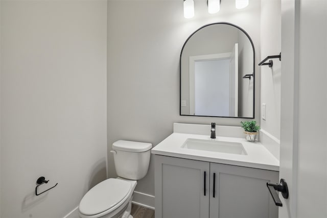 bathroom featuring vanity, wood-type flooring, and toilet