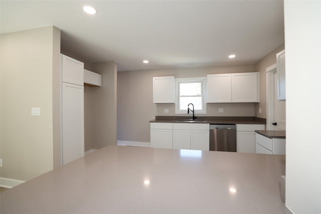 kitchen with sink, stainless steel dishwasher, and white cabinets