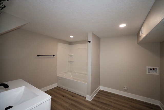 bathroom with  shower combination, vanity, a textured ceiling, and hardwood / wood-style flooring