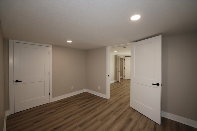 empty room featuring a textured ceiling and dark wood-type flooring