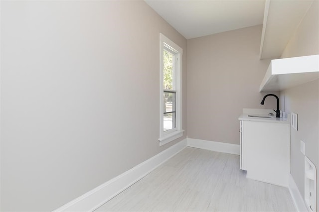 laundry area with baseboards and a sink