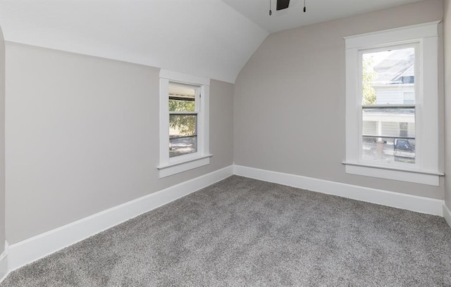 additional living space featuring carpet floors, vaulted ceiling, baseboards, and ceiling fan