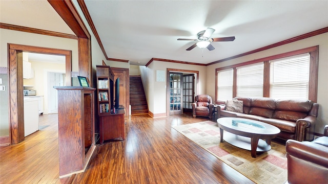 living room with ornamental molding, light wood-type flooring, and ceiling fan