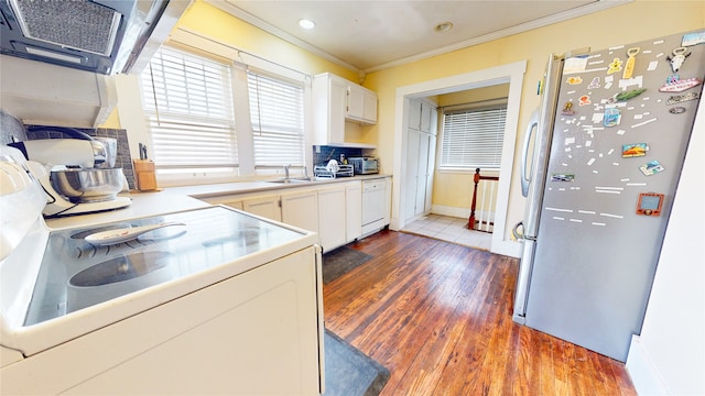 kitchen featuring dark hardwood / wood-style flooring, crown molding, white cabinets, and white appliances