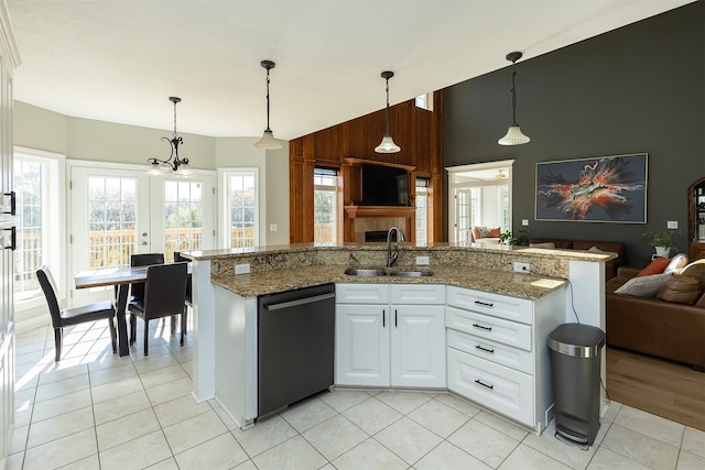 kitchen featuring black dishwasher, white cabinets, a sink, and decorative light fixtures