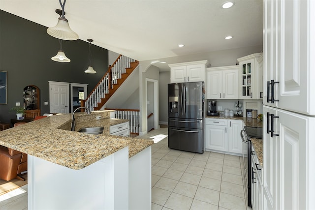 kitchen featuring black range with electric stovetop, fridge with ice dispenser, glass insert cabinets, and white cabinets