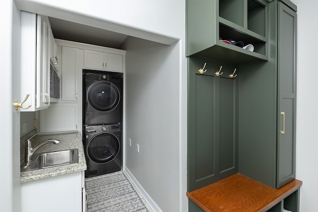 washroom featuring laundry area, a sink, and stacked washer and clothes dryer