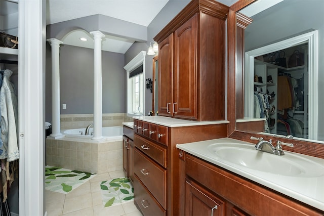 full bathroom with a garden tub, a spacious closet, vanity, tile patterned flooring, and ornate columns