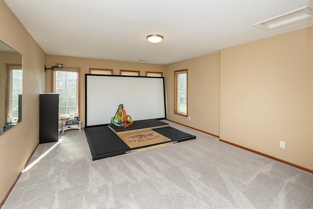 recreation room with light carpet and baseboards